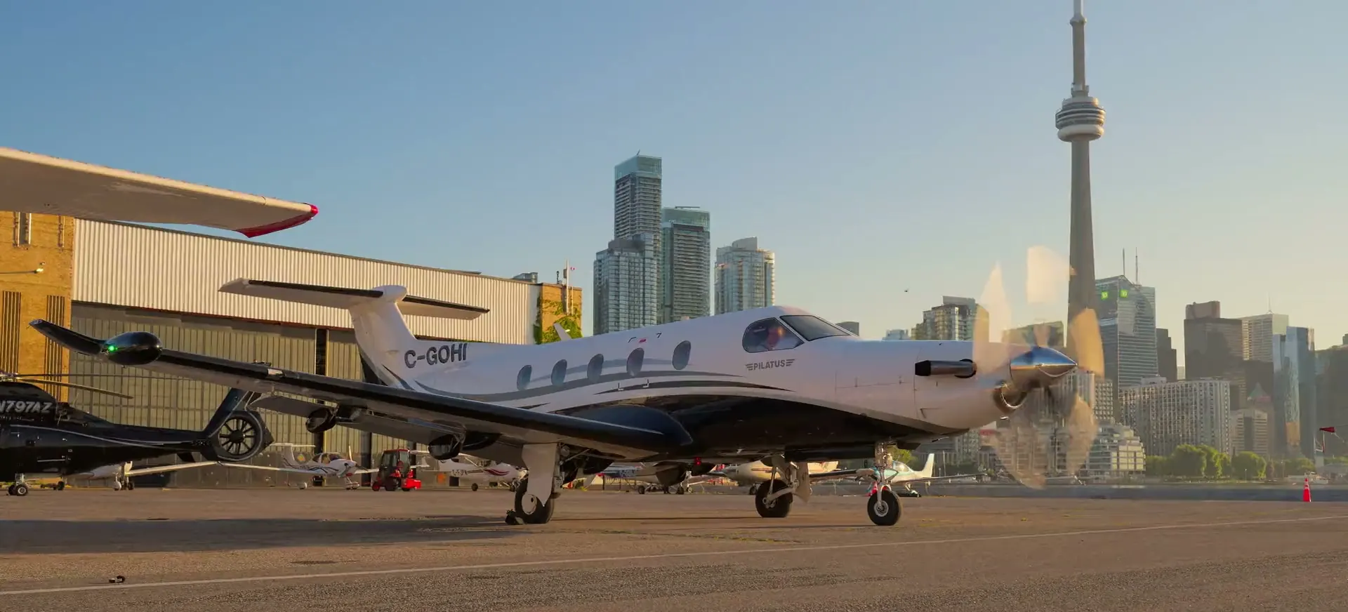 C-GOHI with its engine running on the Billy Bishop ramp, the CN Tower behind